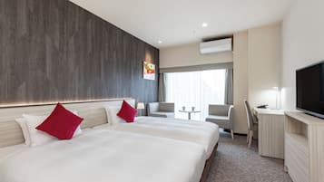 A hotel room with two beds, a desk, a TV, and a window with curtains.