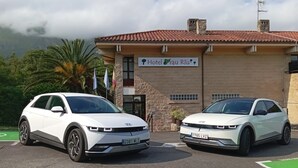 Two white cars parked in front of a building with a sign reading "Hotel Rau Riu". - Prau Riu (Llanes)