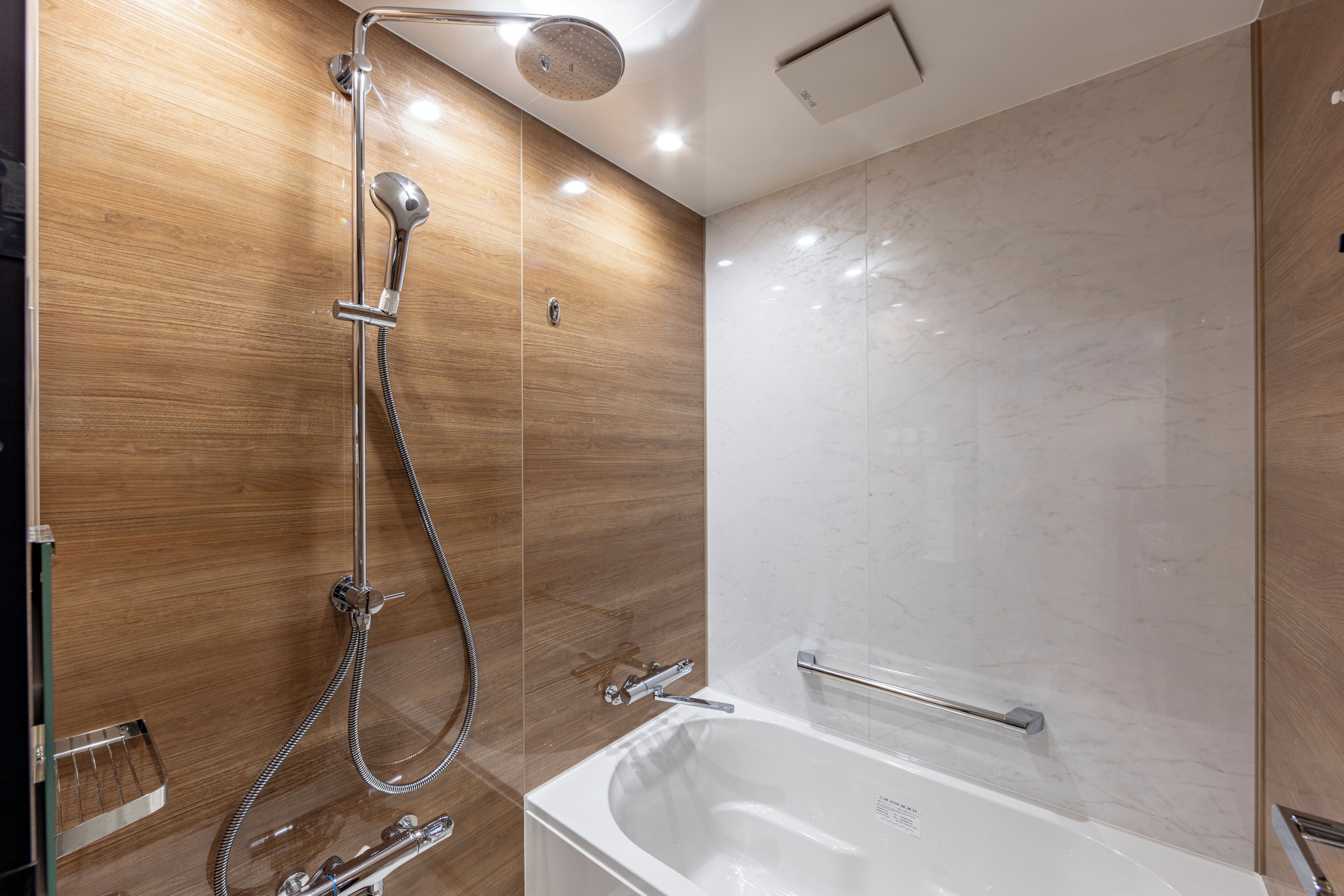 Un baño moderno con ducha, bañera y barra de apoyo.
