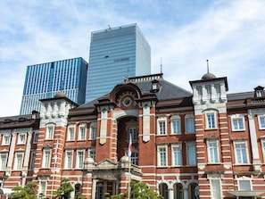 Un bâtiment historique à la façade symétrique, doté de grandes fenêtres et d’une entrée centrale surmontée d’une arche décorative.