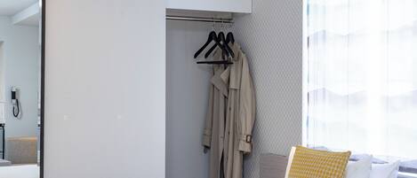 A hotel room with a bed, a wardrobe, and a mirror.