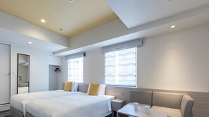 Une chambre d’hôtel moderne avec un grand lit, un coin salon et une petite table.