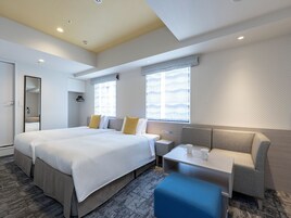 Una habitación de hotel moderna con una cama grande, una zona de estar y una pequeña mesa.