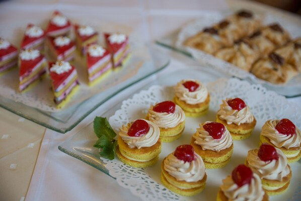 A variety of desserts on a table, including small cupcakes with whipped cream and cherries, and other pastries. - Interhotel Central (Karlovy Vary)