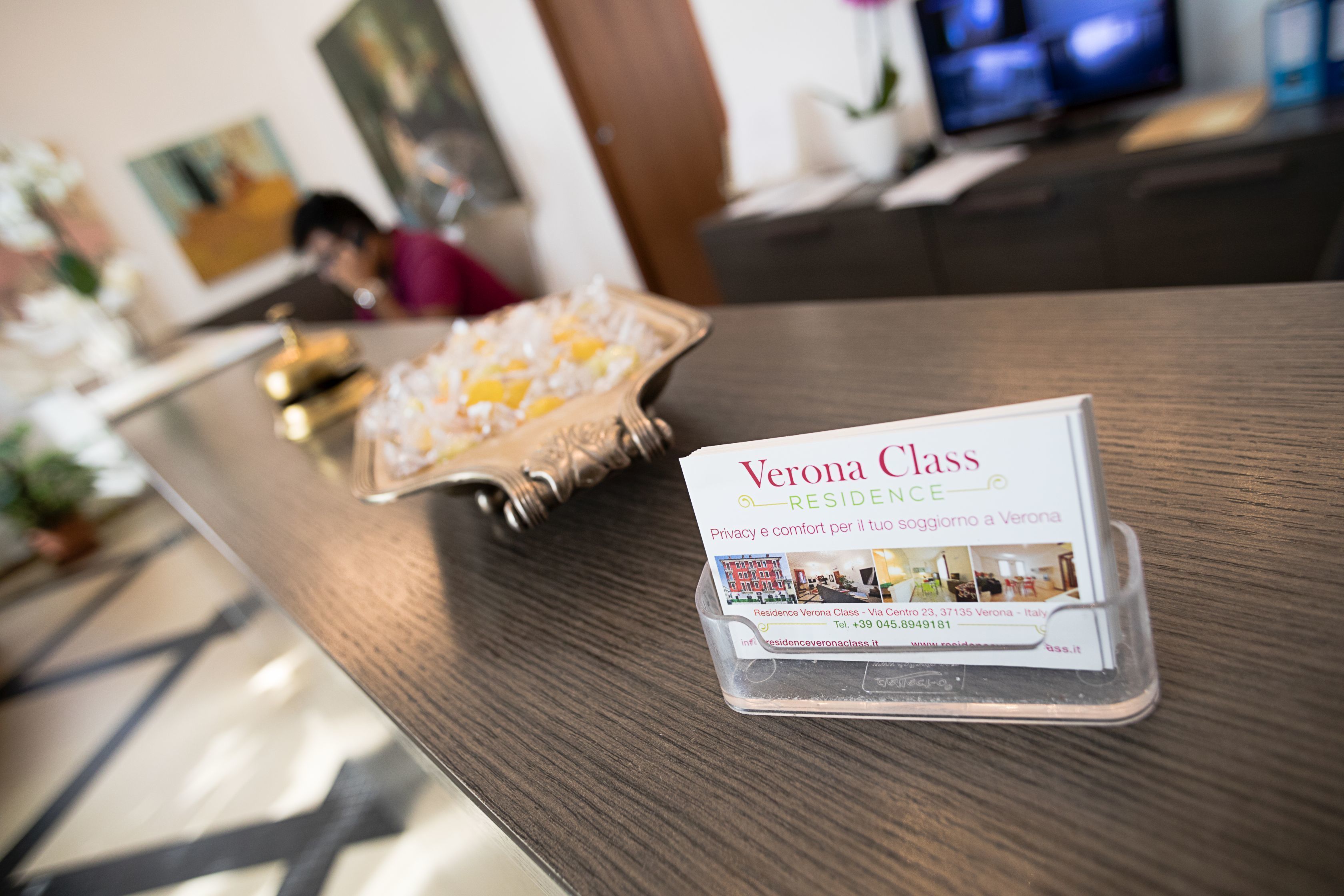 A reception desk with a brochure for Verona Class Residence.