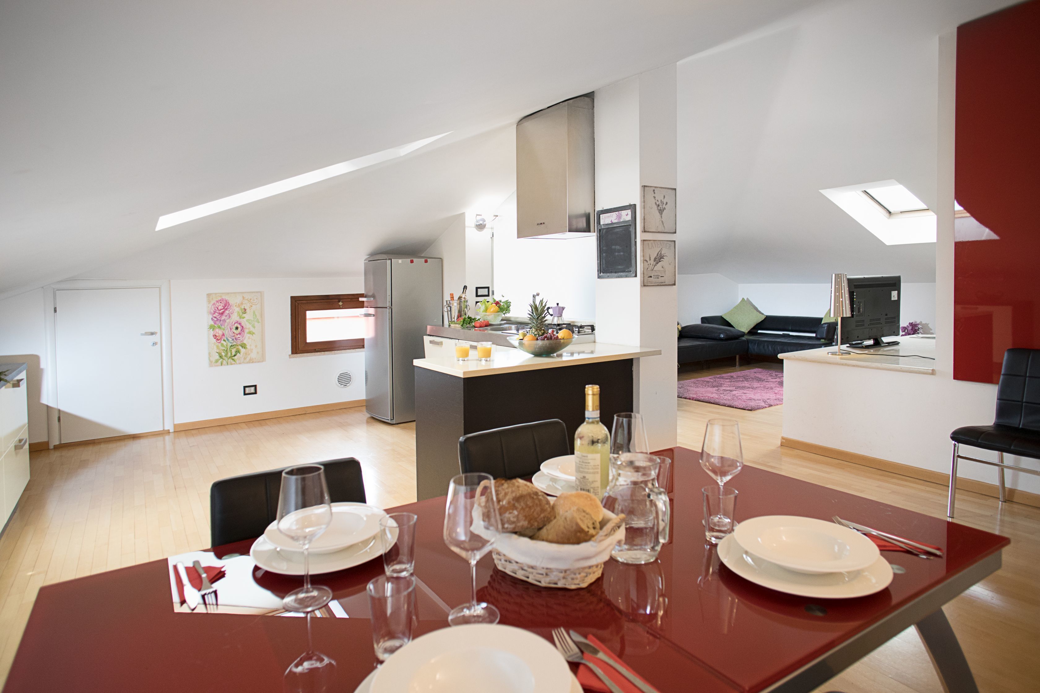 A modern apartment with a dining area, kitchen, and living space.