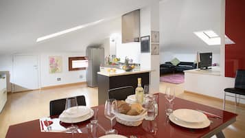 A modern apartment with a dining area, kitchen, and living space.