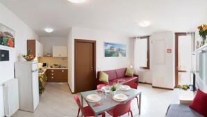 Un espacio habitable compacto con comedor, kitchenette y sofá.