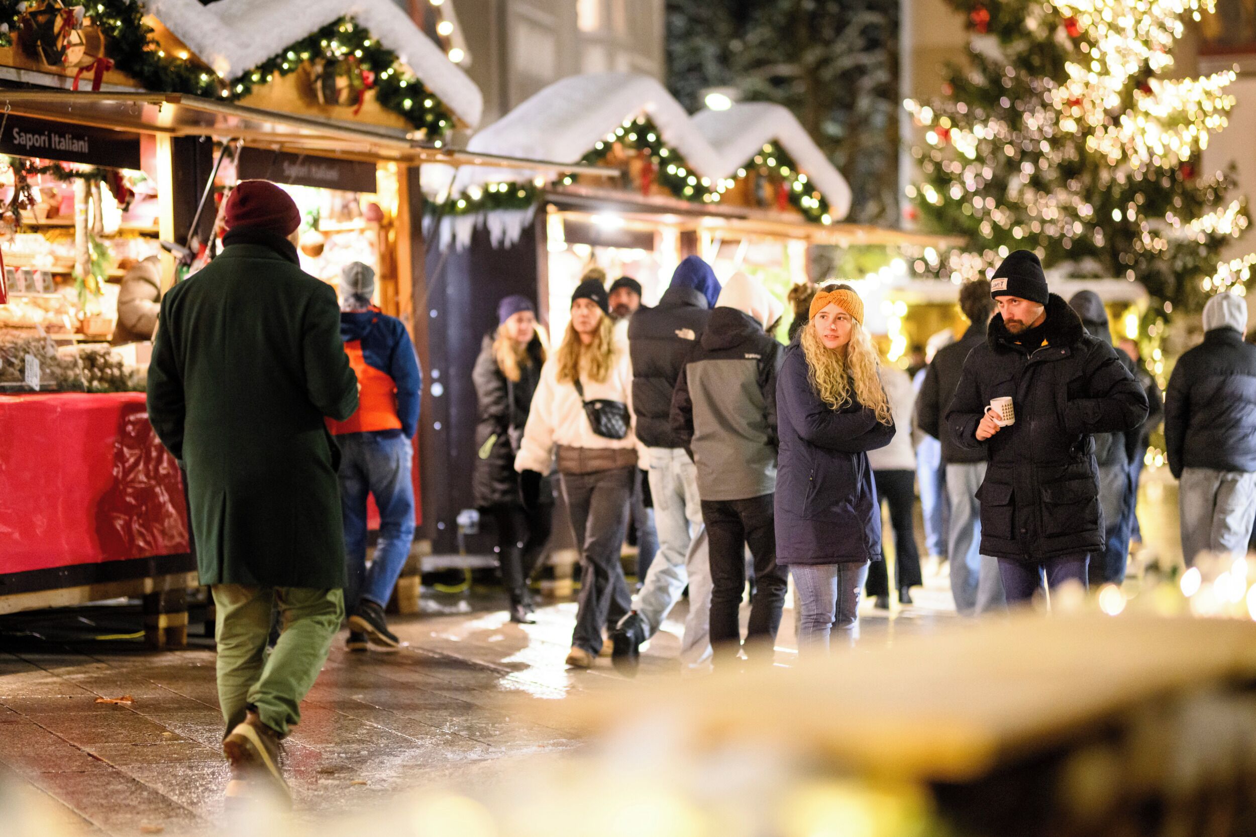 Een levendige openbare markt met mensen die lopen en kraampjes vol koopwaar.