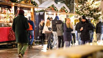 Een levendige openbare markt met mensen die lopen en kraampjes vol koopwaar.