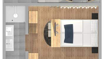 A top-down view of a modern hotel room with a wooden floor, a bed, a desk, a chair, a wardrobe, and a bathroom.
