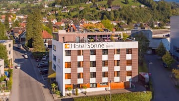 Een modern hotelgebouw met een bord waarop staat: Hotel Sonne Garni.