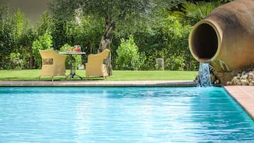 Una piscina al aire libre de temporada, sillones reclinables de piscina