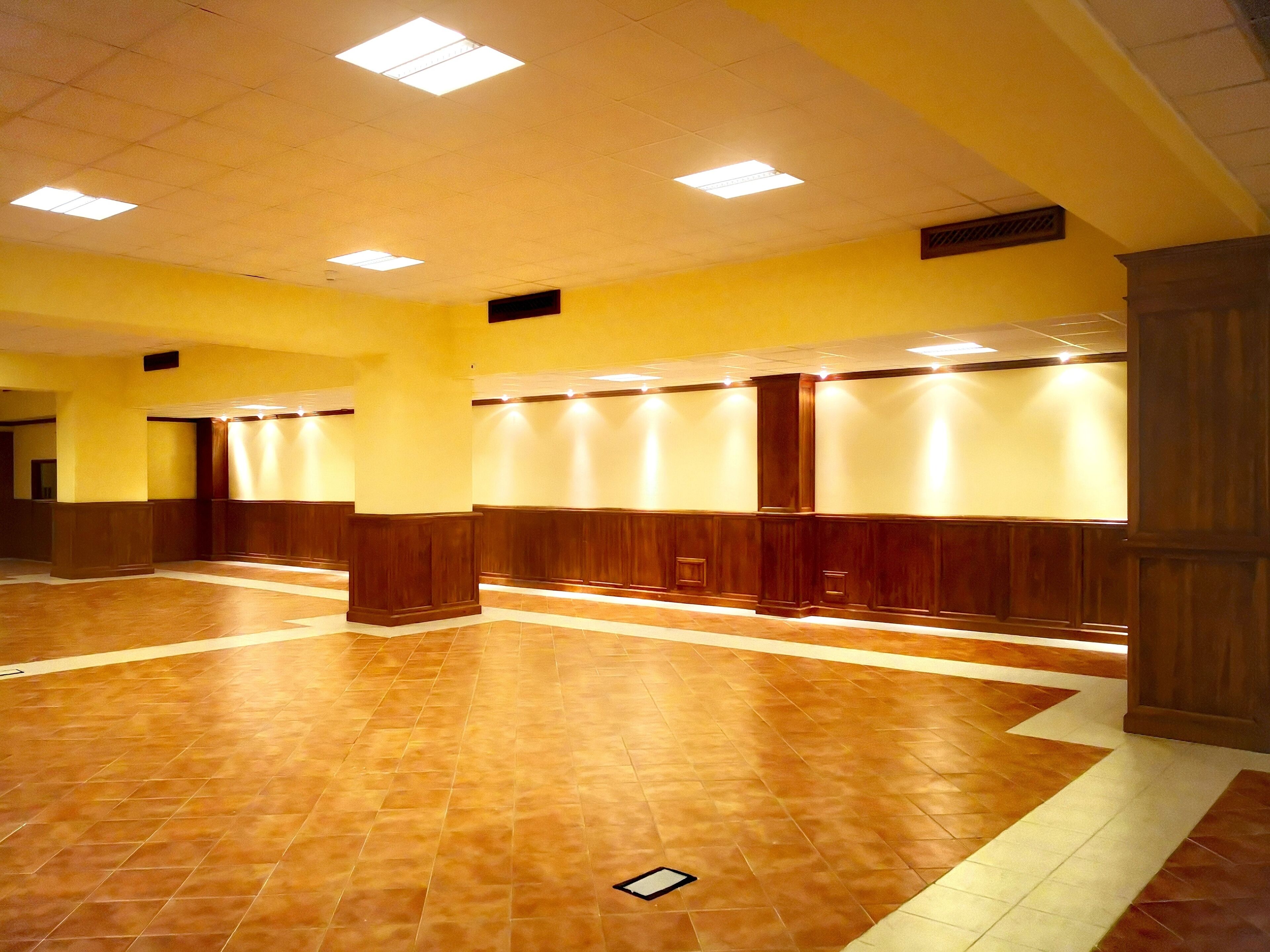 Un vestíbulo amplio con piso de baldosas y paneles de madera en las paredes.