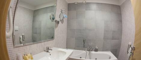 Een badkamer met twee wasbakken, een bad en een toilet.