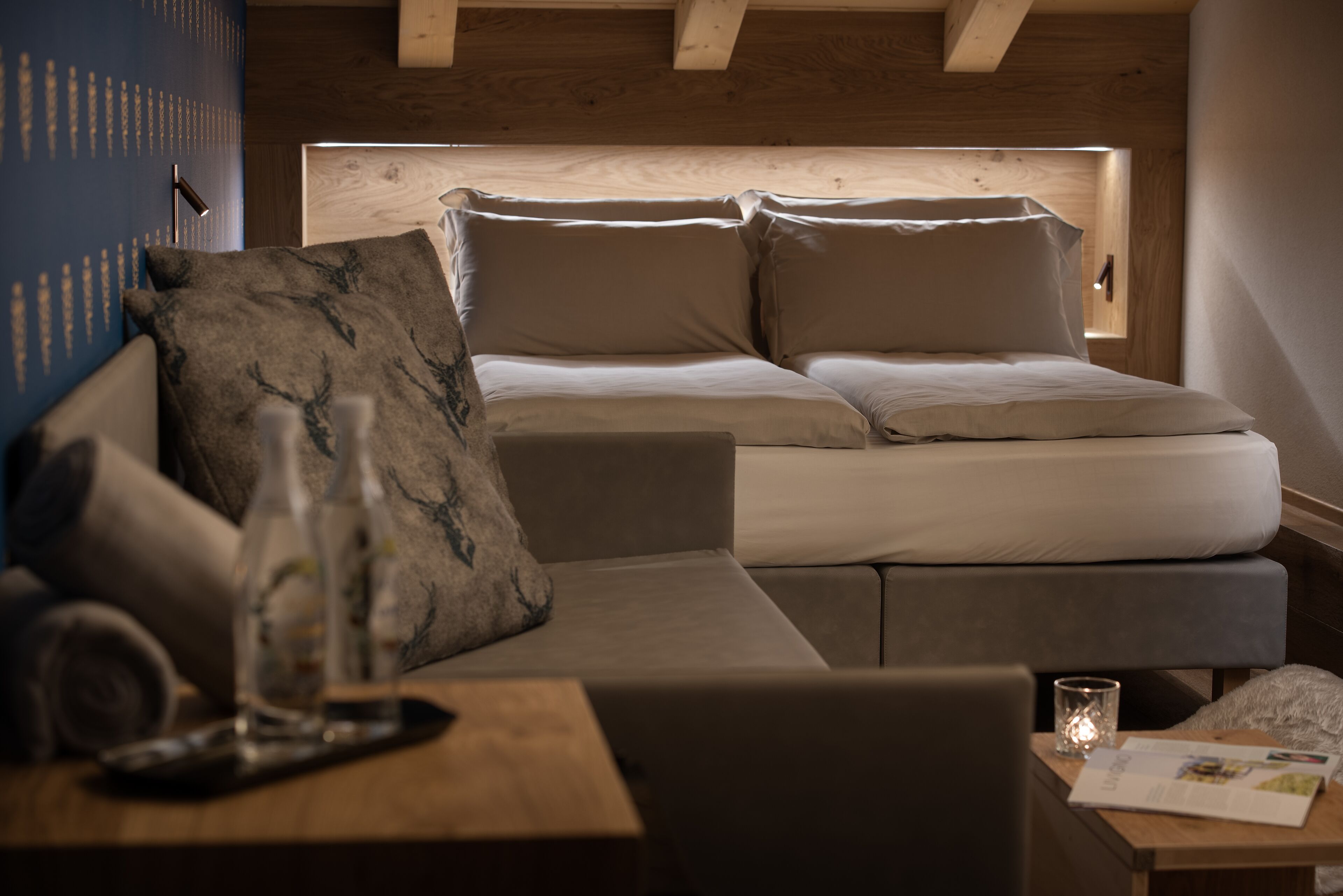 Un dormitorio moderno con cama, sofá, una mesita y una mesita de noche.