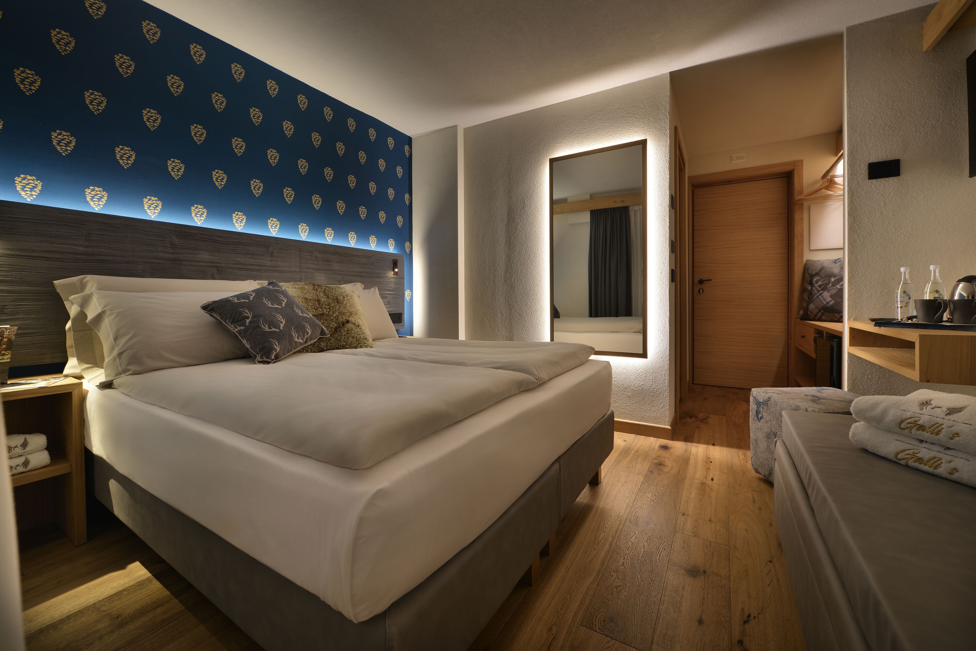 Ein Schlafzimmer mit einem großen Bett, einem Nachttisch, einem Kleiderschrank und einem Spiegel.