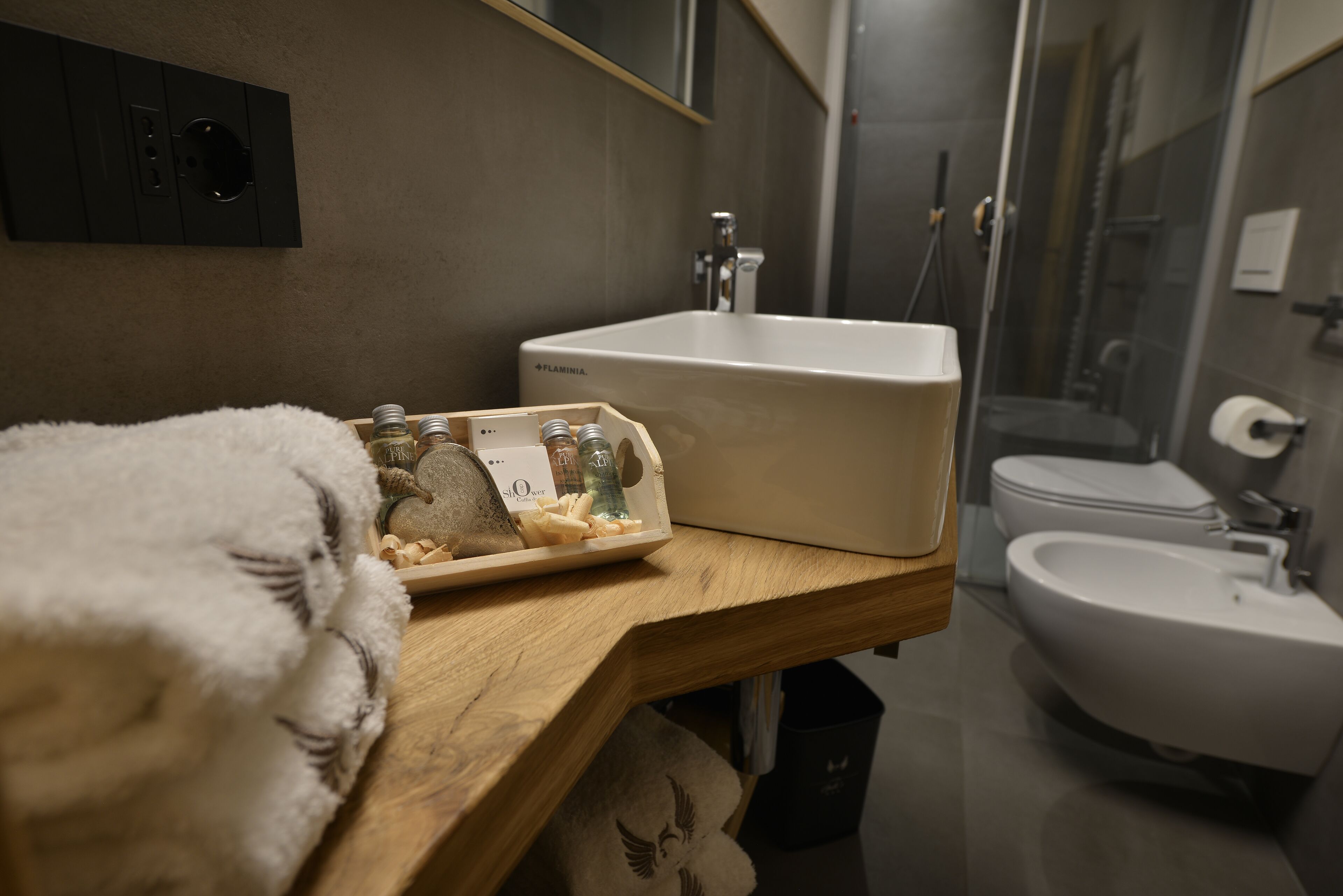 Un baño con tocador de madera, lavabo blanco y bidé.