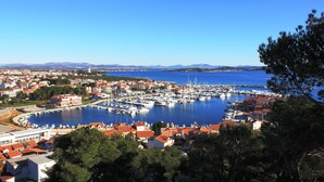 A coastal town with a marina, houses with red roofs, and a clear blue sky. - Villa Diana (Tribunj)