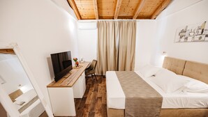 A bedroom with a wooden ceiling, a bed with white bedding, a desk with a computer, and a window with curtains. - Villa Diana (Tribunj)