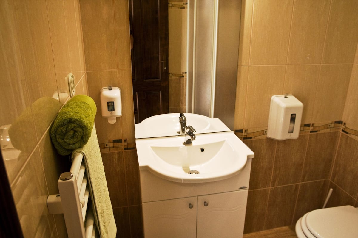 A bathroom with a white sink, a towel, and a toilet.