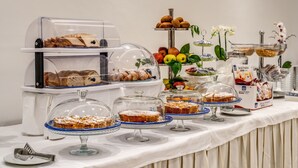 A buffet with various baked goods, fruits, and a coffee station. - Hotel Florida (Sorrento)
