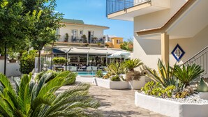 A courtyard with a pool, potted plants, and outdoor seating. - Hotel Florida (Sorrento)