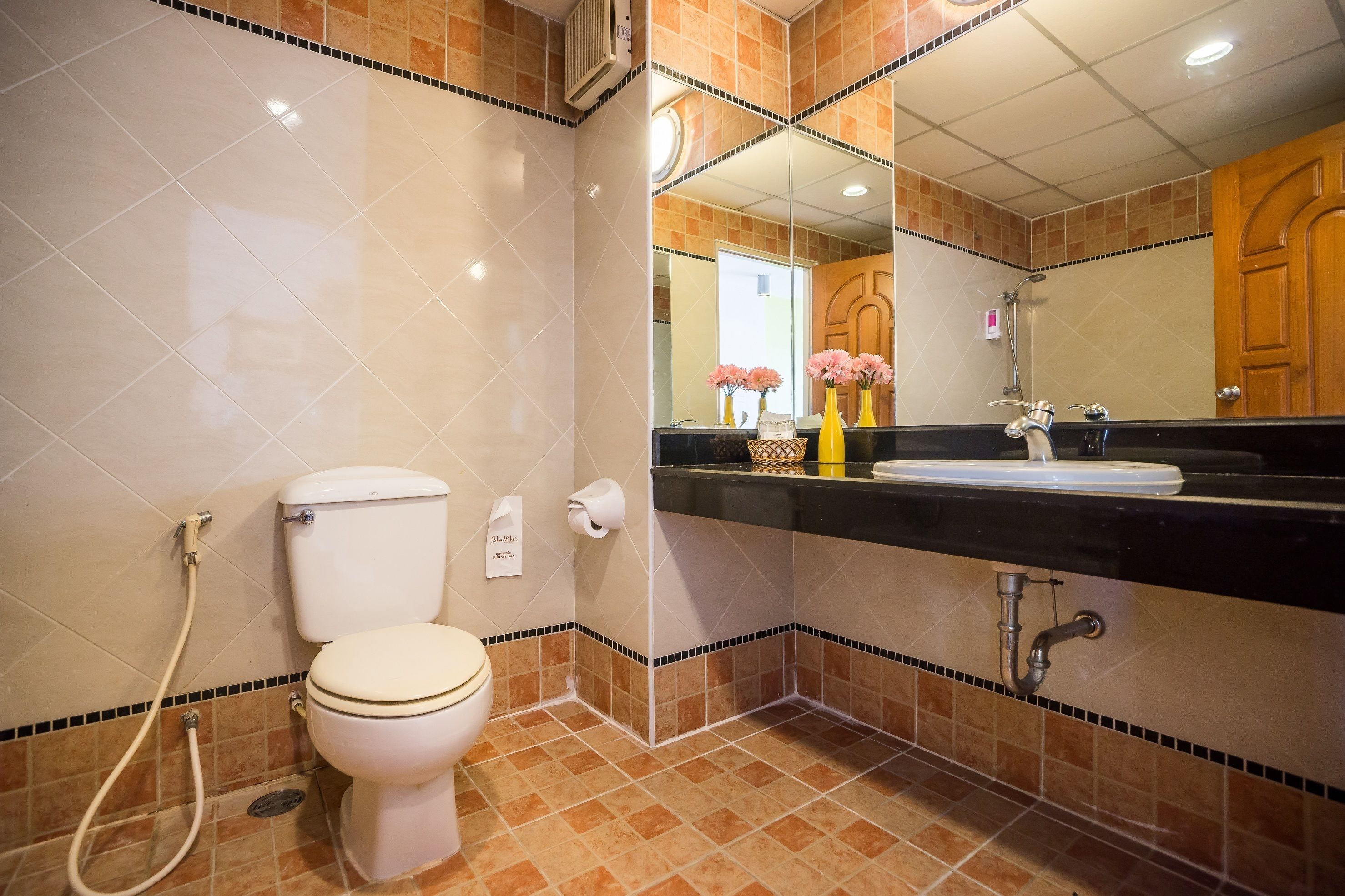 A bathroom with a toilet, sink, and mirror.