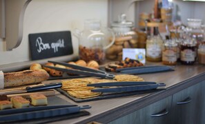 A breakfast buffet with various pastries, sandwiches, and condiments.