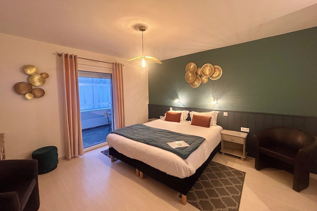 Een moderne hotelkamer met een groot bed, een nachtkastje, een stoel, een decoratieve wand en uitzicht door het raam.