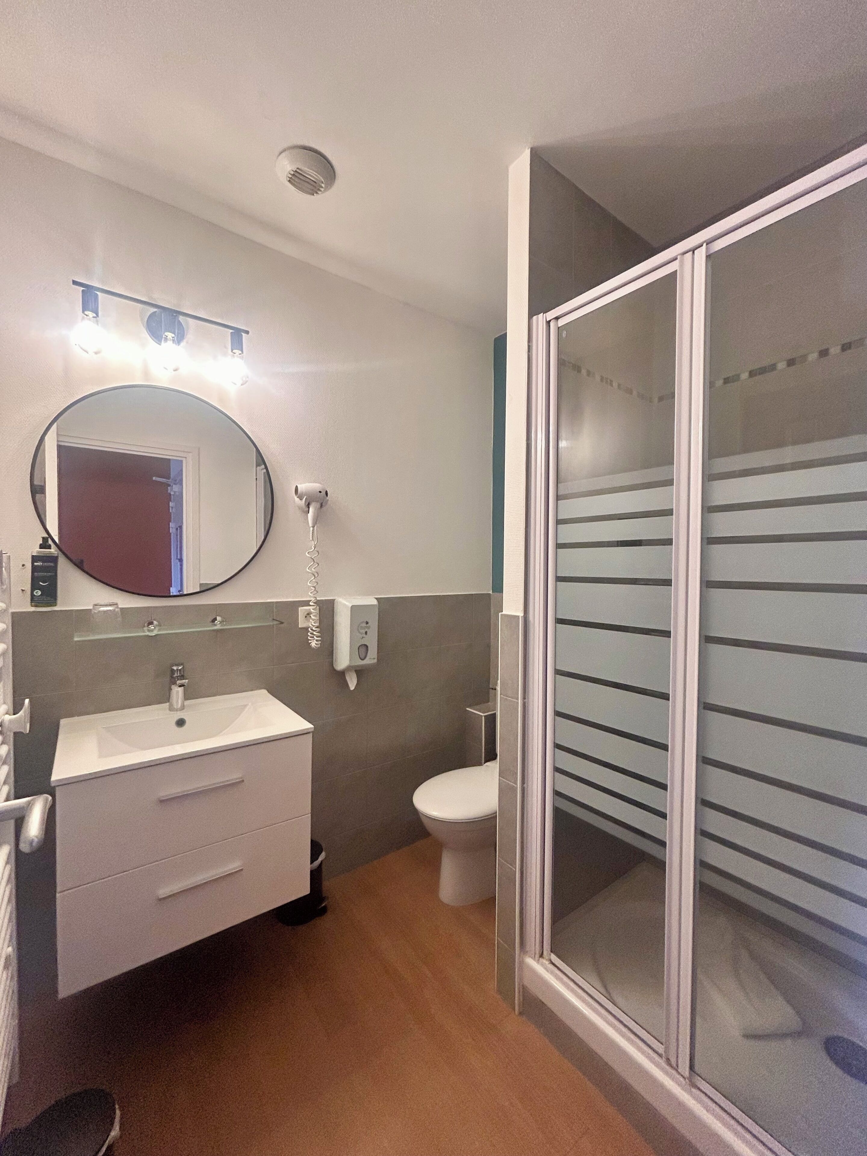 Une salle de bain moderne avec un lavabo, un miroir et des toilettes.