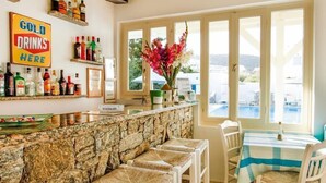 A bar area with a stone counter, bar stools, and a 'Cold Drinks Here' sign. - Anemos Studios & Apartments (Mykonos)