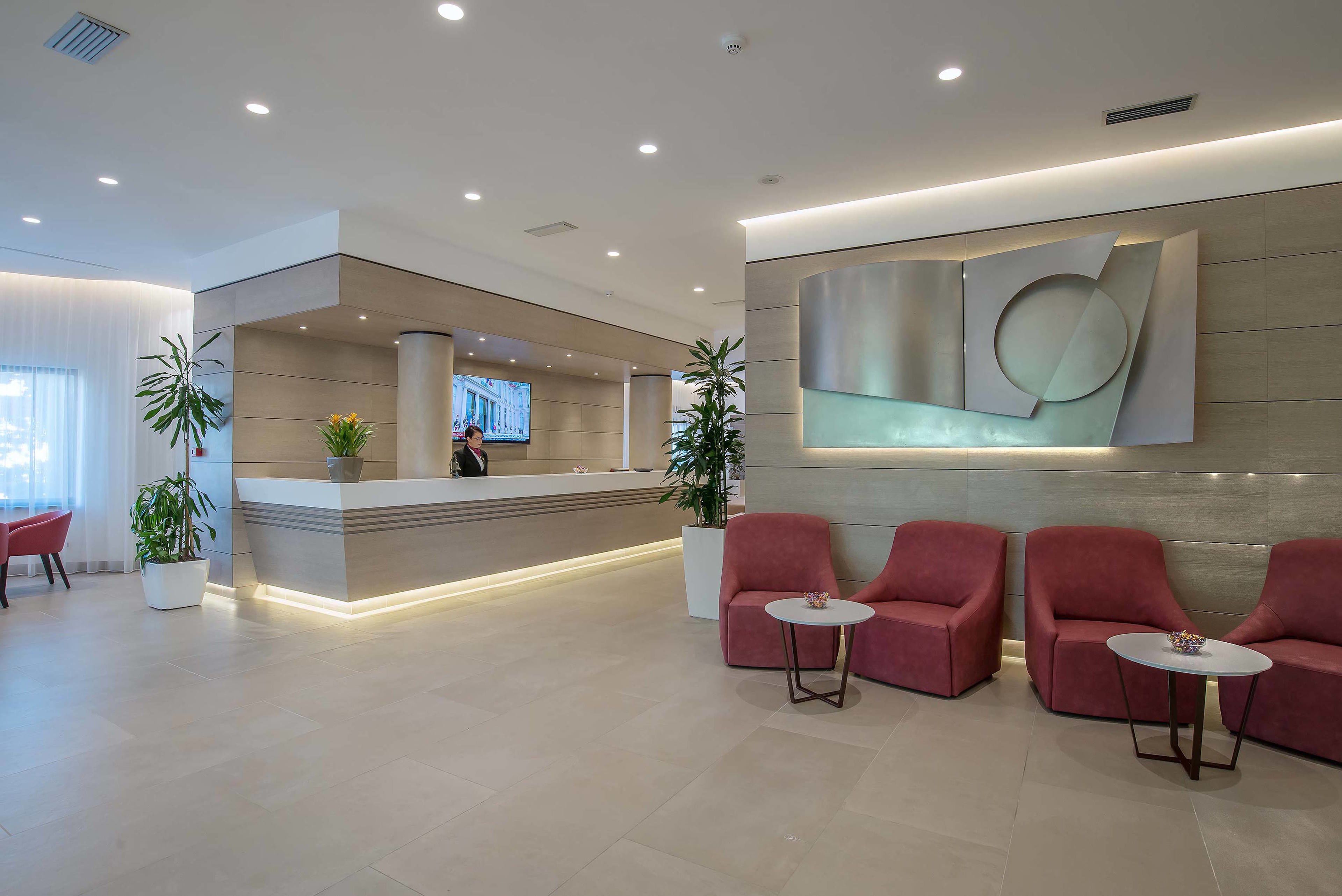 A modern reception area with a reception desk, seating area, and decorative wall art.