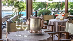 A dining area with a table set for two, a large pot, and two glasses of white wine. - Hotel La Giocca (Rome)