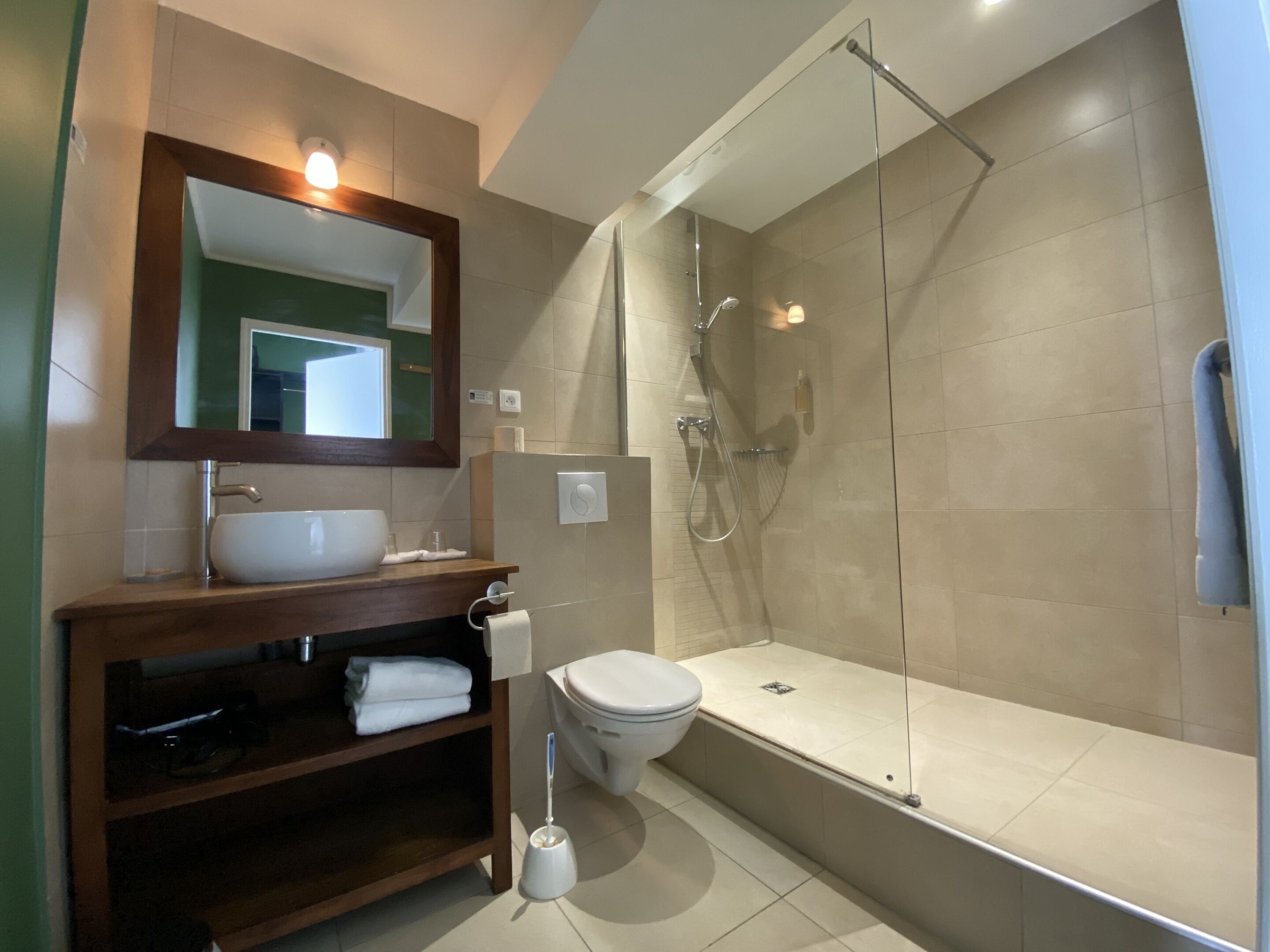 Een moderne badkamer met een douchecabine, een bad en een wastafel met spiegel.