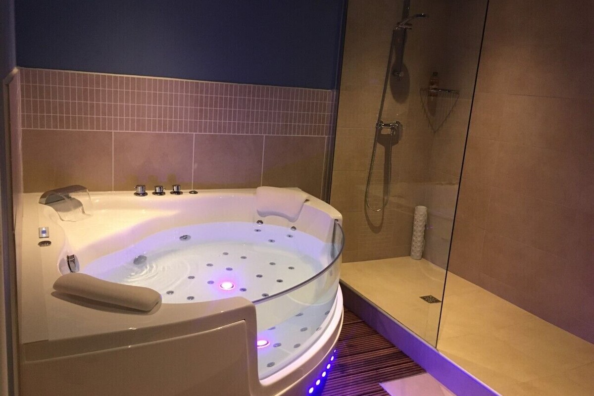 A modern bathroom with a freestanding bathtub, a glass-enclosed shower, and a walk-in shower.