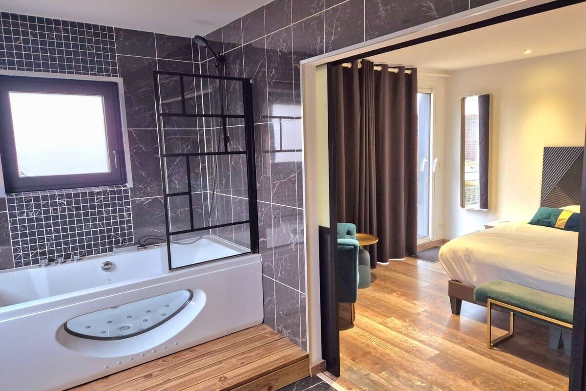 A modern bathroom with a bathtub, a shower, and a vanity.