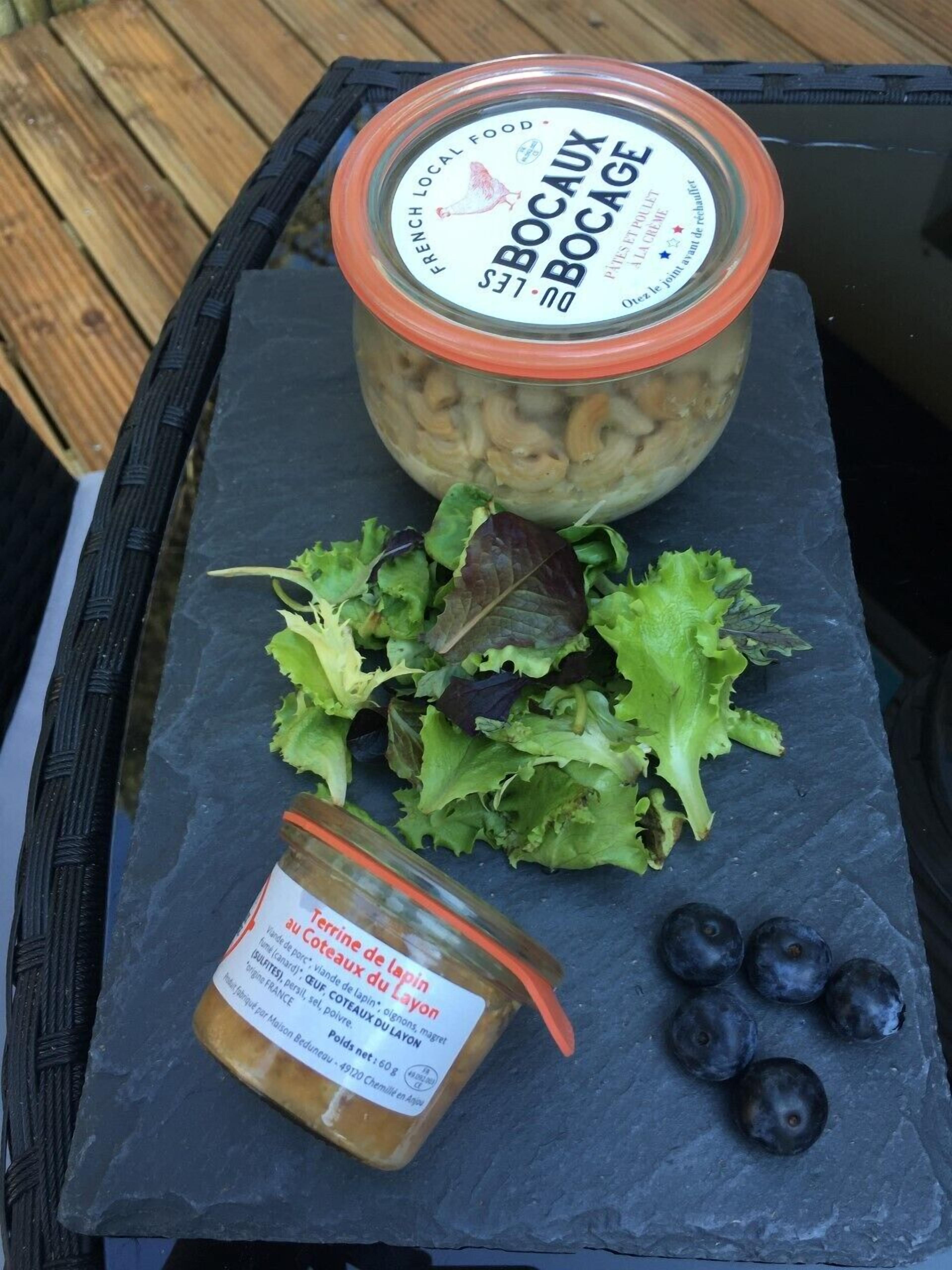 Een pot Frans streefgerecht, een salade en bosbessen op een arduinen bord.