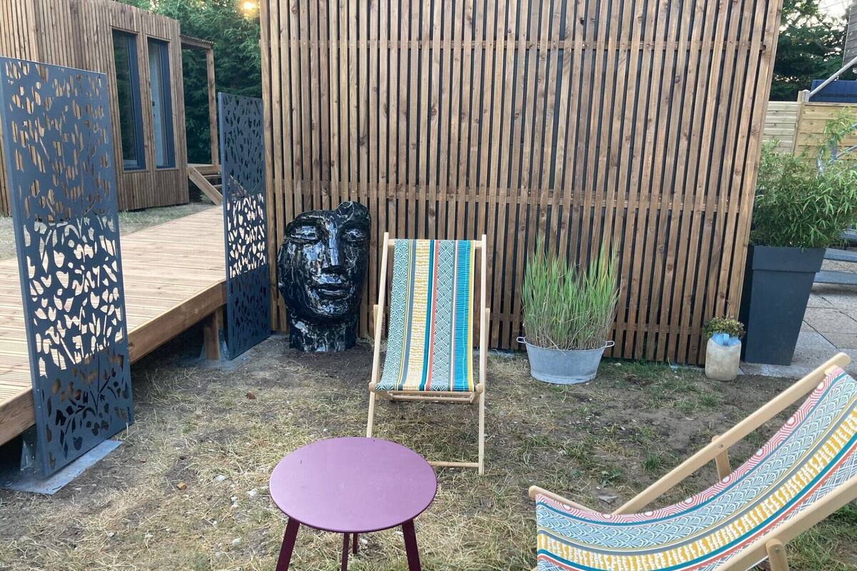 A wooden deck with a purple table and two striped chairs.