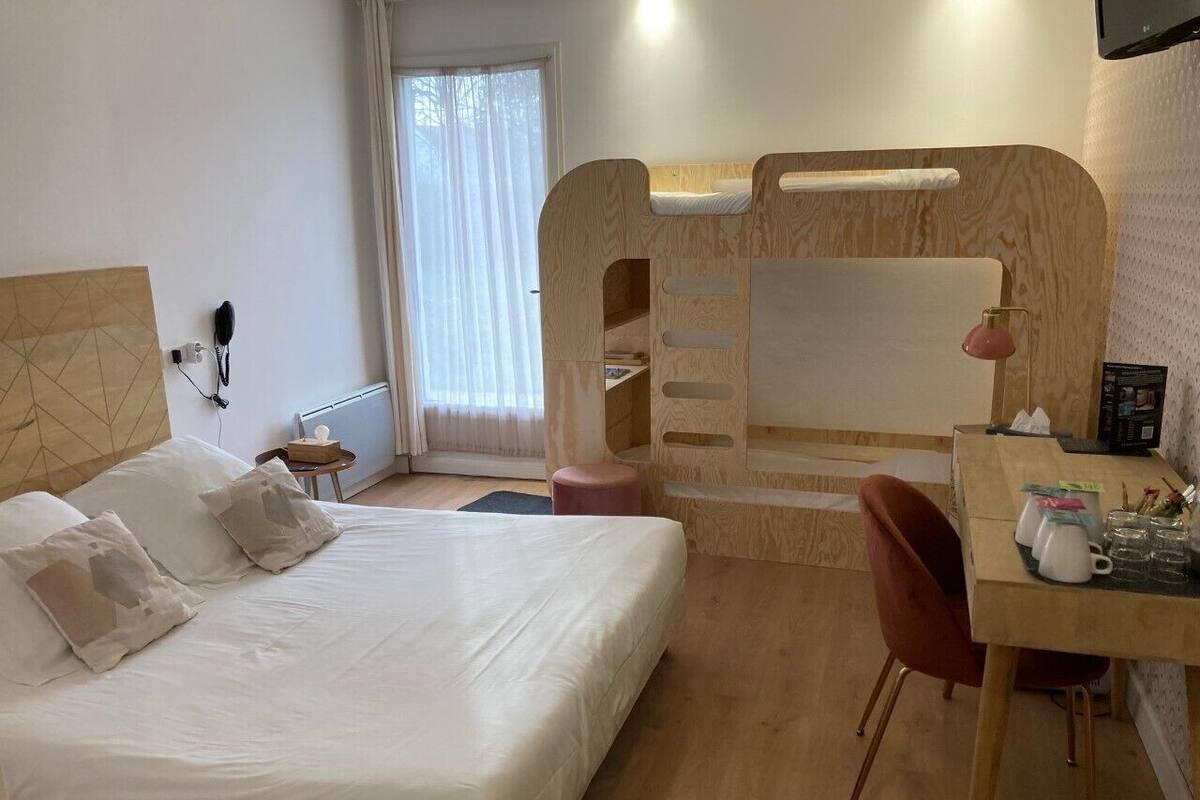 A bedroom with a bed, a desk, and a bunk bed.