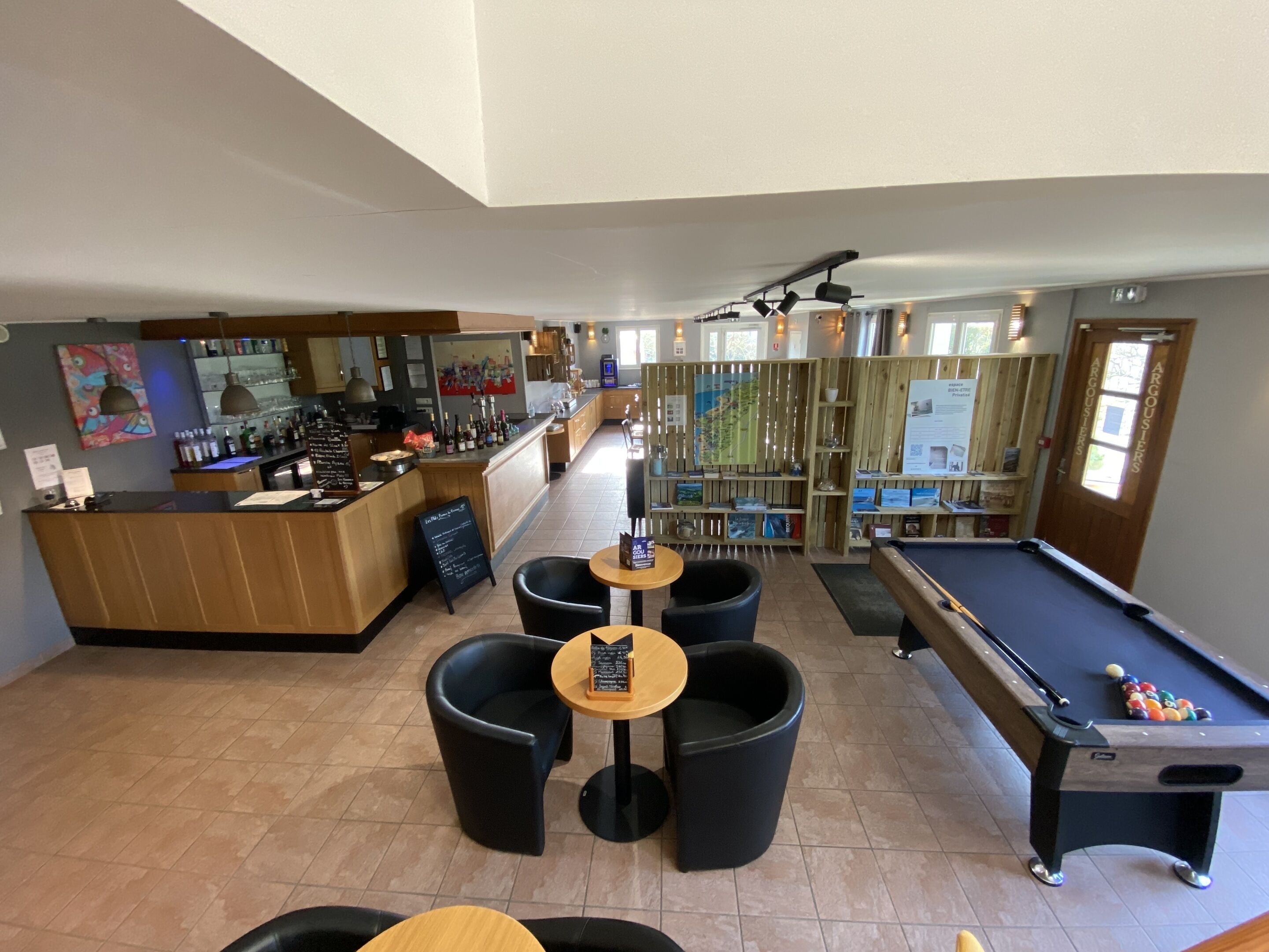 A pool table, bar area, and seating with a view of the pool.