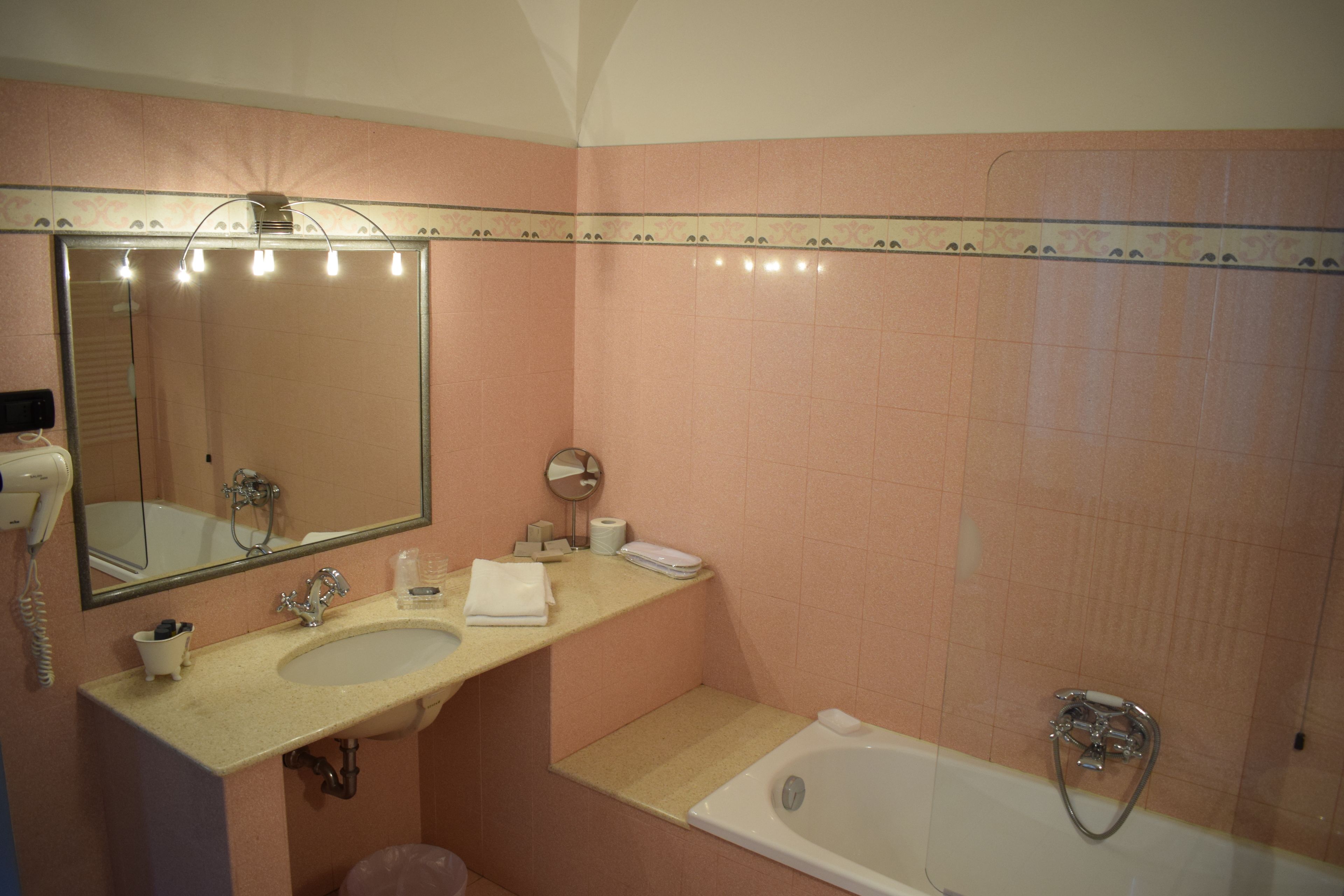Un baño con lavabo, espejo y bañera.