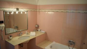 Un baño con lavabo, espejo y bañera.