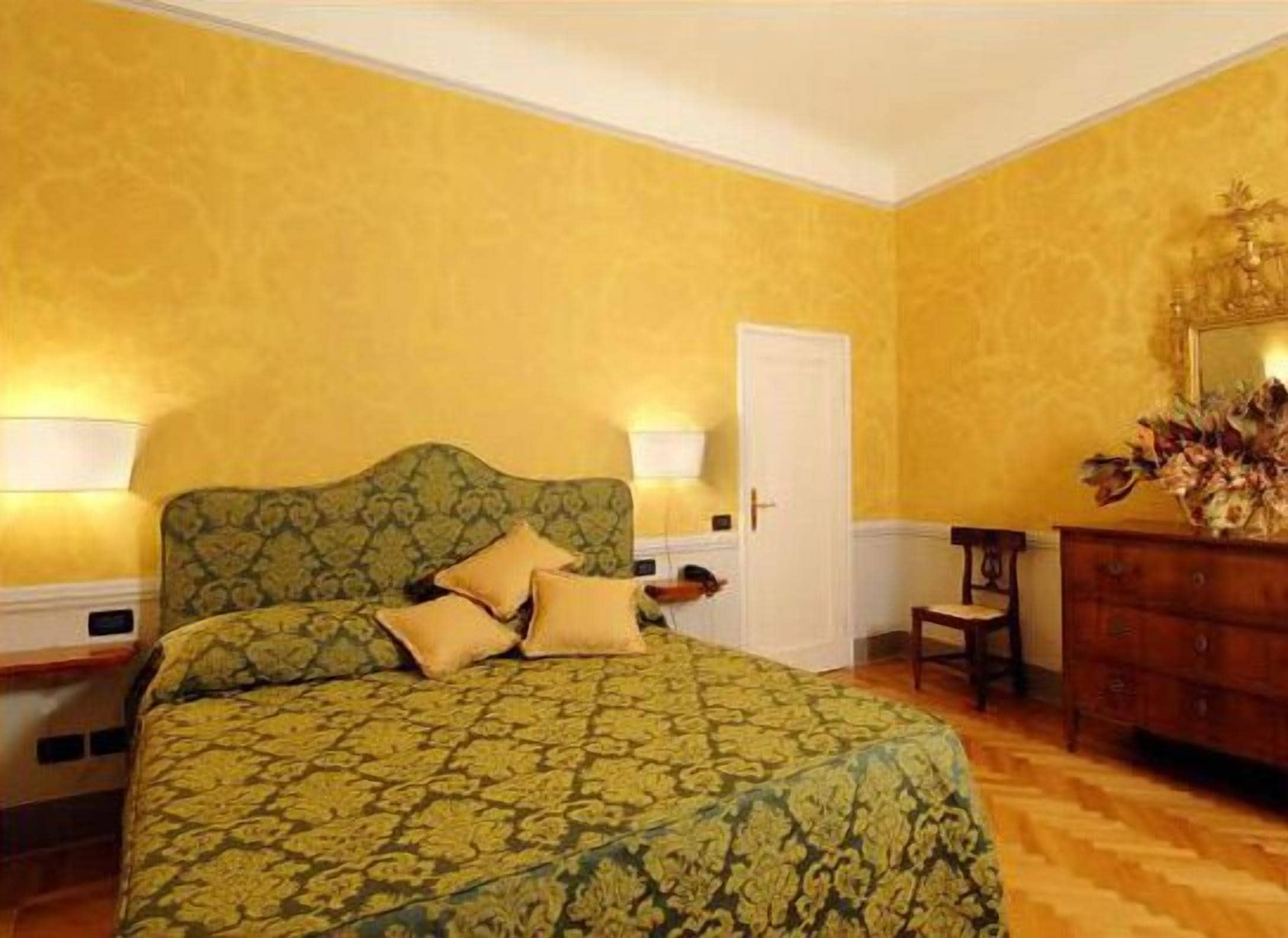 A room with a bed, a dresser, and a door.
