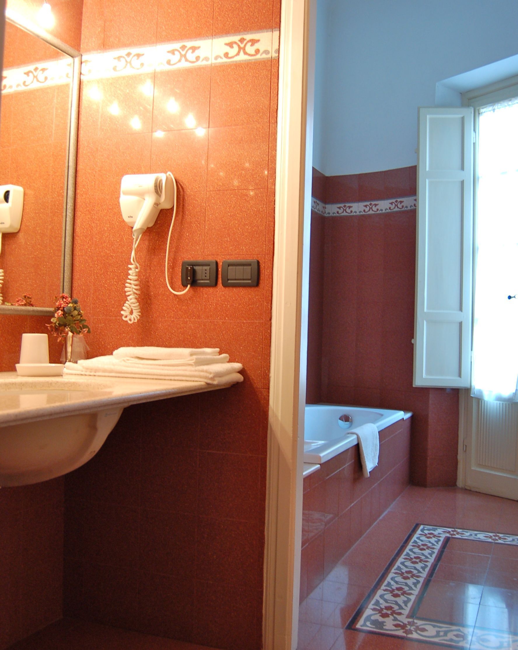 Un baño con lavamanos, secador de pelo y bañera.