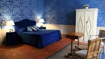 Ein Schlafzimmer mit einem Bett, zwei Nachttischen, einer Kommode und einem Sessel.