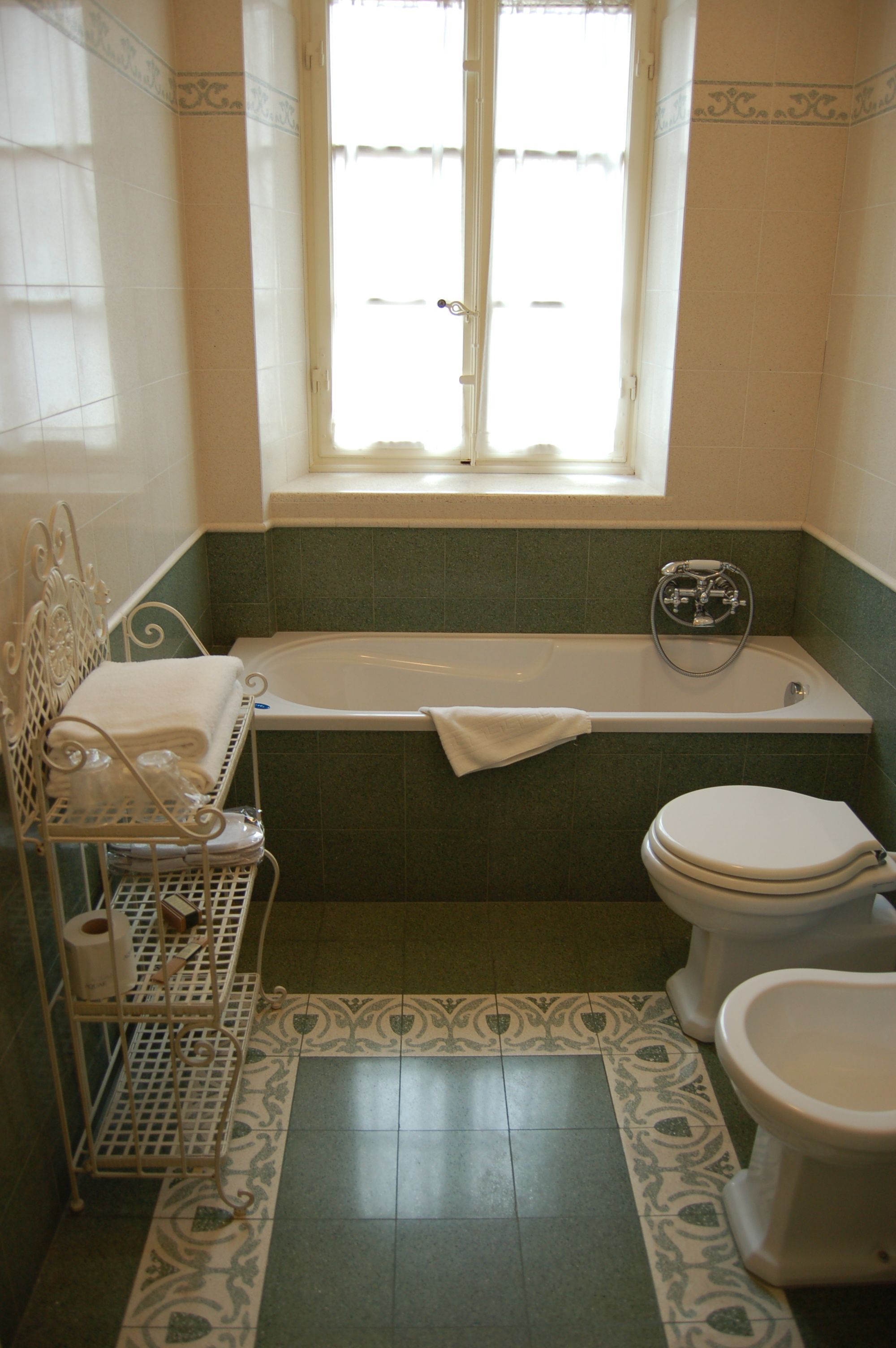 Een badkamer met een bad, toilet en een raam.