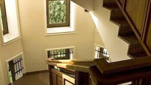 A staircase with wooden railings and a window with a view of greenery. - Villa Belvedere (Belgrade)