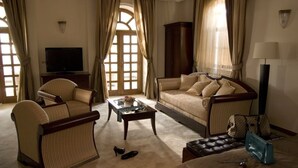 A living room with a sofa, armchairs, a coffee table, a TV, and a lamp. - Villa Belvedere (Belgrade)