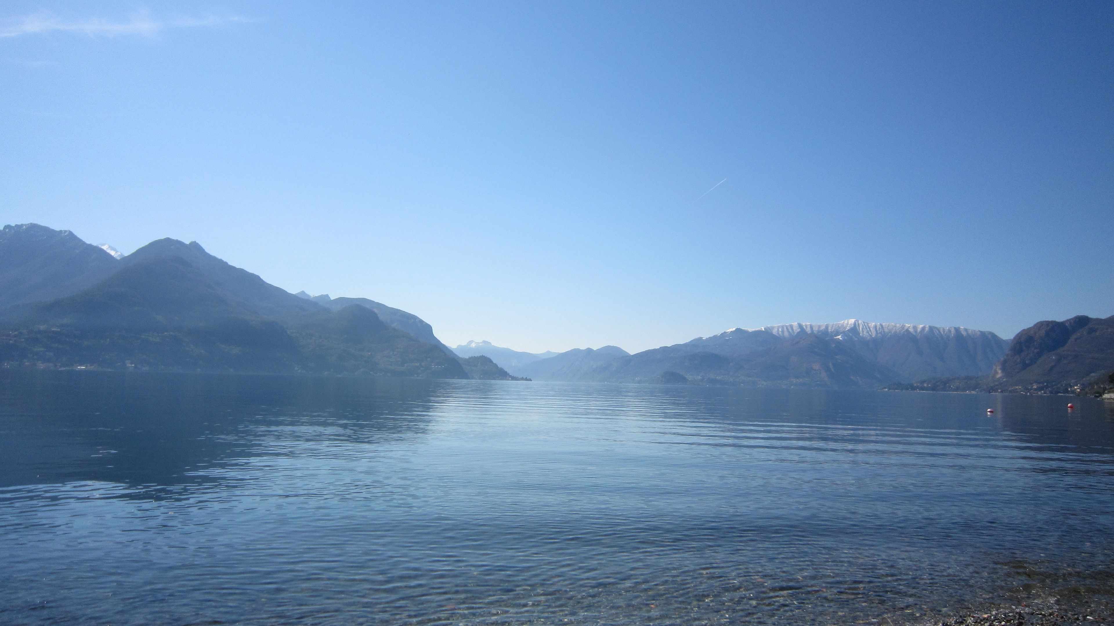 A calm lake with mountains in the background.